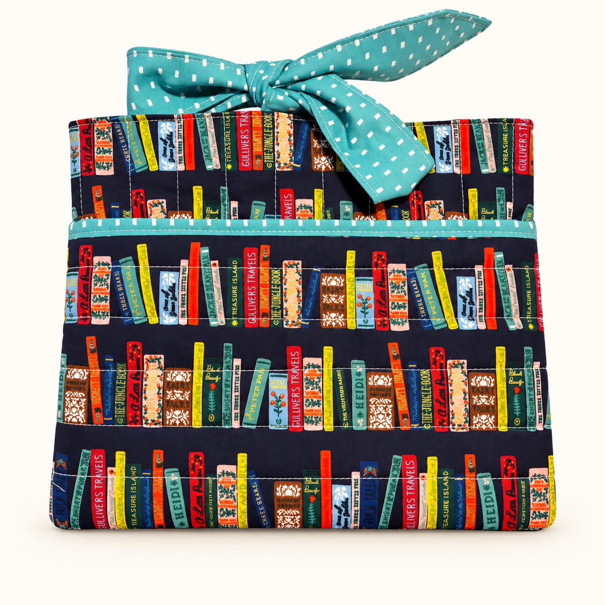 Handmade quilted book sleeve with front pocket and bow closure
